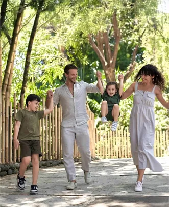Parents and children enjoying a sunny nature walk on a tropical vacation with our bali tour package for family.