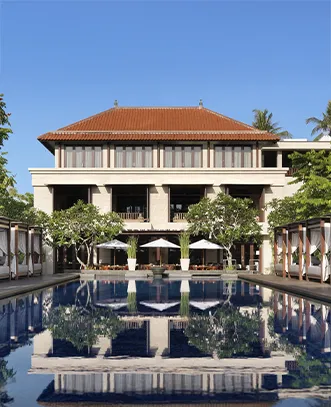 Elegant luxury resort in Bali with a large reflection pool and poolside cabanas, included in our premium international bali tour package