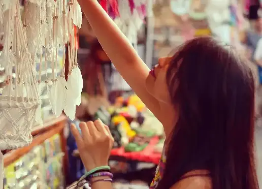 Explore the local culture and find unique treasures in Bali with this image of a woman shopping for handicrafts.