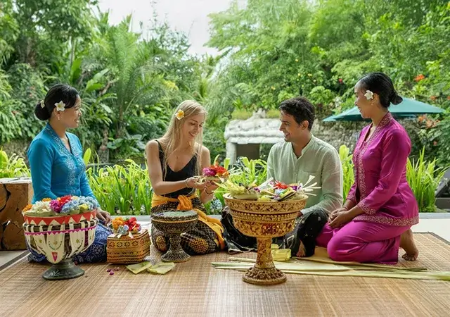 Friends gathered on the grass, sharing a meal, highlighting the joy of Bali tour packages and local culinary delights.