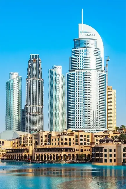 Luxury Emaar waterfront hotels in Downtown Dubai reflecting in the water, representing premium accommodation in international tours.