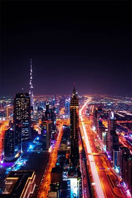 Night view of the glowing Dubai skyline and Sheikh Zayed Road, showcasing the vibrant nightlife and modern architecture.
