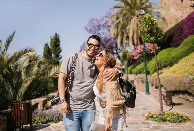 Smiling tourists exploring a beautiful outdoor destination with lush greenery