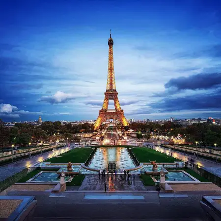 The Eiffel Tower stands tall in Paris at dusk, bathed in soft lights, creating a magical evening atmosphere.