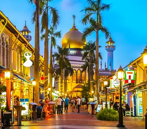 Travelers exploring the glowing streets of Kampong Glam by the Sultan Mosque, a highlight of premier Singapore vacation packages from India.