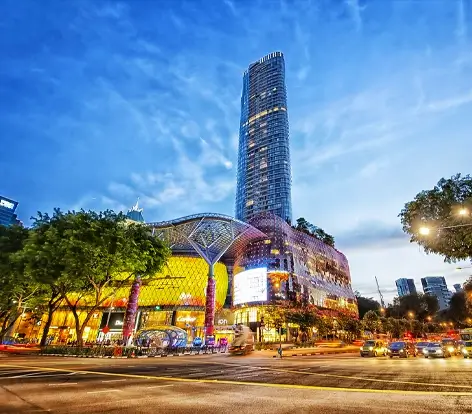Vibrant evening view of luxury malls on Orchard Road, a highlight of premier Singapore tour packages.