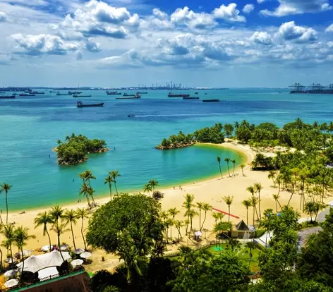 Aerial view of the turquoise waters and palm trees at Siloso Beach on Sentosa Island, a top relaxation spot