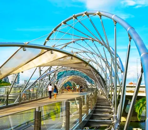Tourists walking across the architectural Helix Bridge at Marina Bay, a must-visit spot included in our Singapore vacation packages from India
