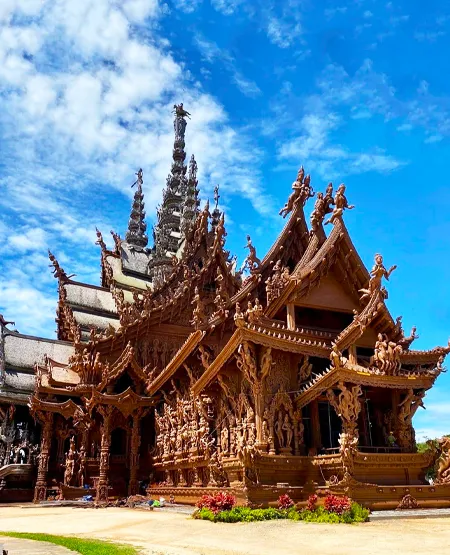 The soaring, all-wooden Sanctuary of Truth temple in Pattaya, showing intricate carvings.