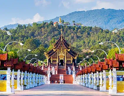 Traditional Thai temple surrounded by green mountains.