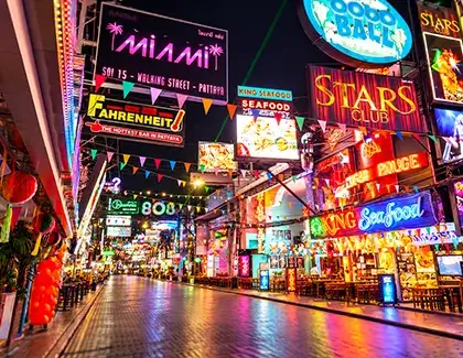  Colorful nightlife street filled with restaurants and neon signs.